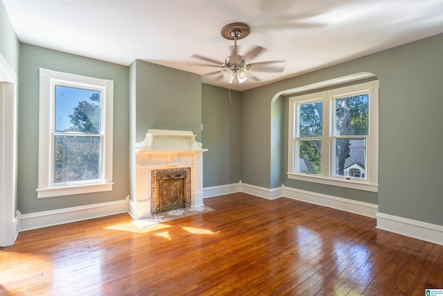 unfurnished living room featuring plenty of natural light, hardwood / wood-style floors, and ceiling fan