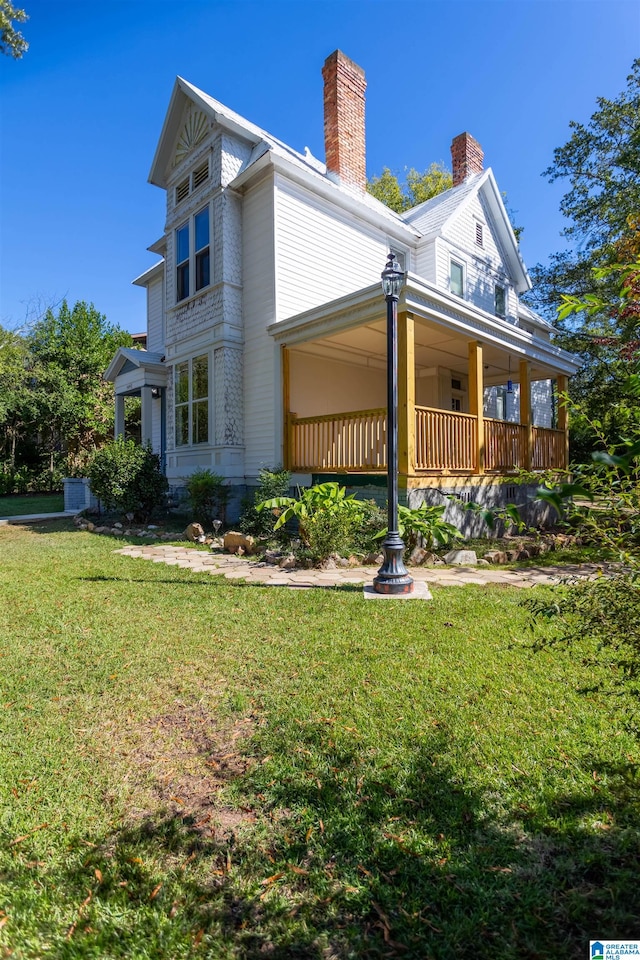 back of property with a porch and a yard