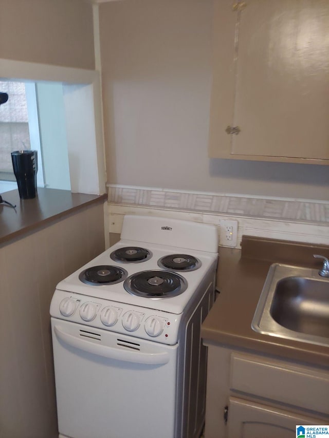 kitchen featuring white cabinetry, sink, and white electric range