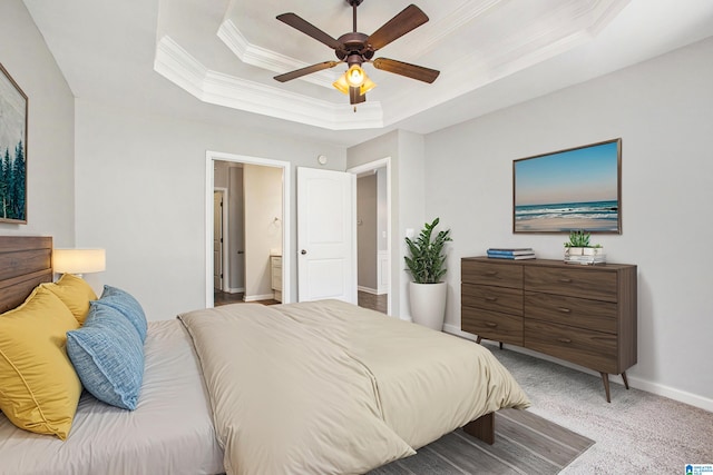 carpeted bedroom with ensuite bath, ceiling fan, crown molding, and a raised ceiling