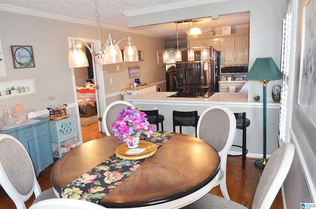 dining area with ornamental molding, dark hardwood / wood-style floors, and a textured ceiling