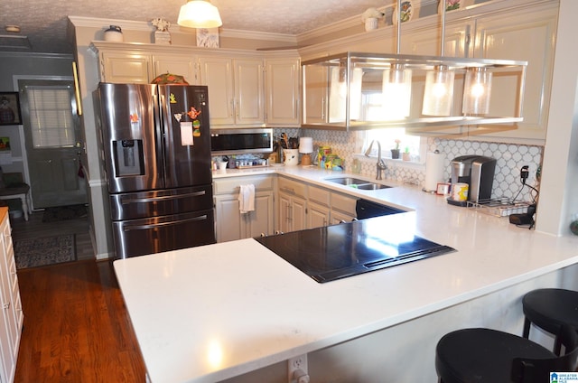 kitchen with hanging light fixtures, sink, kitchen peninsula, stainless steel fridge with ice dispenser, and dark hardwood / wood-style flooring