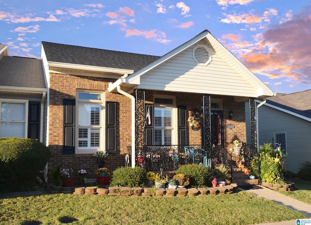 view of front of property featuring a porch and a lawn