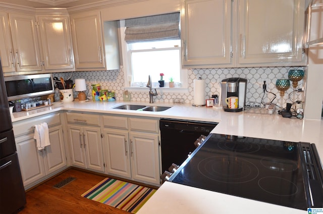 kitchen featuring tasteful backsplash, dark hardwood / wood-style flooring, sink, black appliances, and white cabinetry