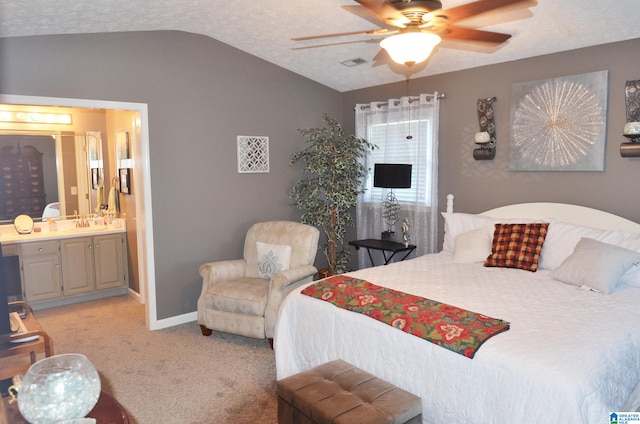 carpeted bedroom with lofted ceiling, ensuite bathroom, a textured ceiling, and ceiling fan