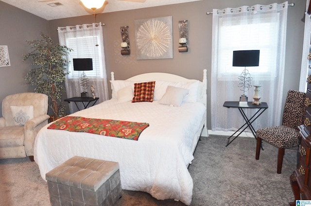 bedroom featuring ceiling fan, a textured ceiling, and carpet flooring