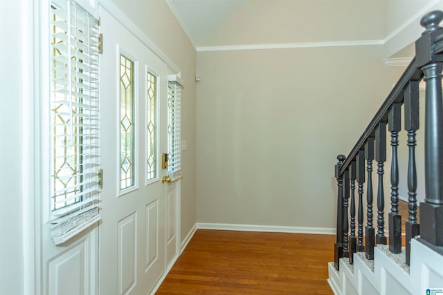 entryway with wood-type flooring, ornamental molding, and a healthy amount of sunlight