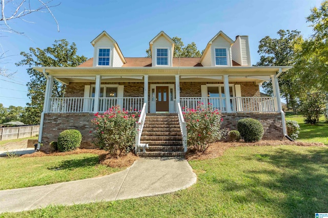 cape cod home featuring a porch and a front lawn