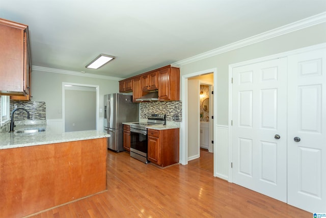 kitchen with decorative backsplash, sink, crown molding, light hardwood / wood-style flooring, and appliances with stainless steel finishes