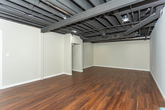 basement with dark hardwood / wood-style floors