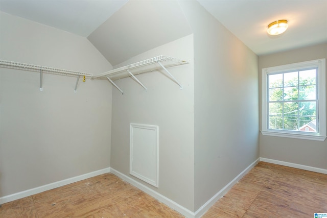 walk in closet with lofted ceiling and light hardwood / wood-style flooring