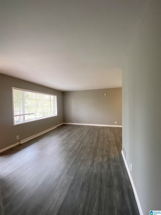 unfurnished room with dark hardwood / wood-style floors and a baseboard radiator