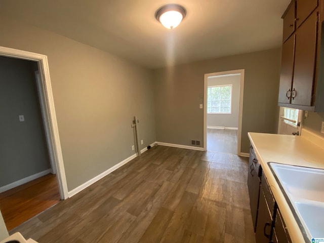 clothes washing area featuring sink and dark hardwood / wood-style floors