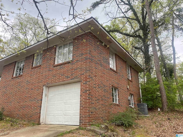 view of home's exterior with a garage and central AC unit