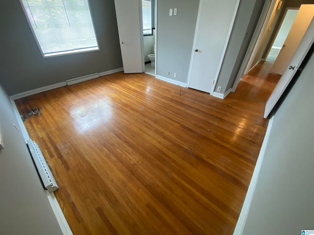 unfurnished bedroom featuring light wood-type flooring and ensuite bath