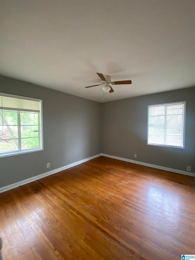 unfurnished room with ceiling fan, hardwood / wood-style flooring, and a healthy amount of sunlight