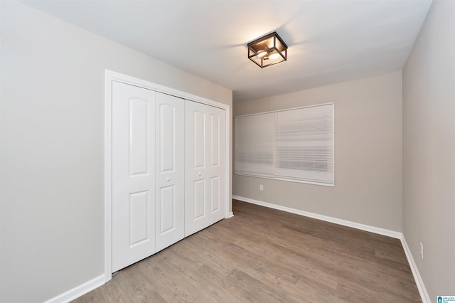 unfurnished bedroom featuring light hardwood / wood-style flooring and a closet