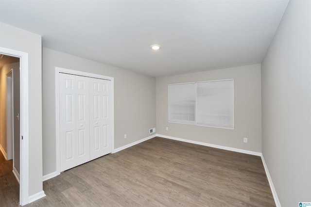 unfurnished bedroom featuring wood-type flooring and a closet