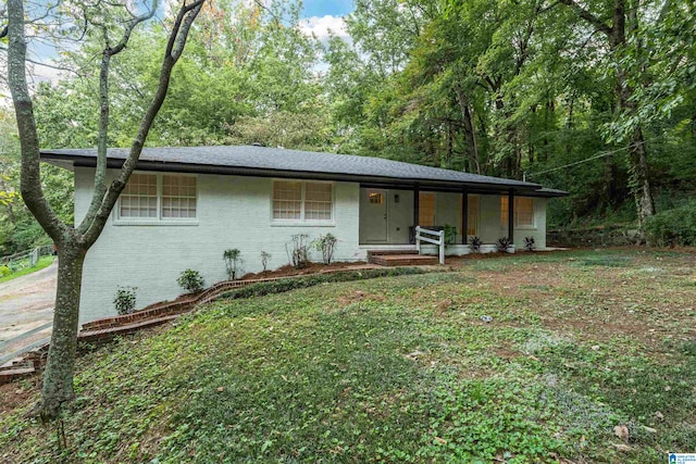 ranch-style house with a porch and a front lawn