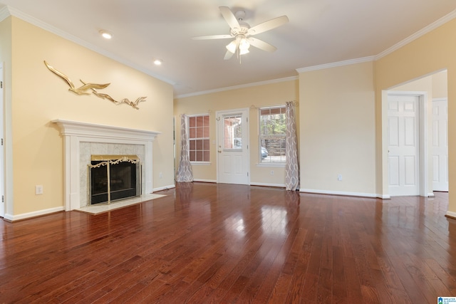 unfurnished living room with dark wood-type flooring, ceiling fan, ornamental molding, and a tile fireplace