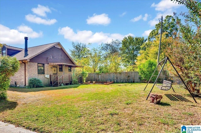view of side of property with fence, a yard, roof with shingles, and brick siding