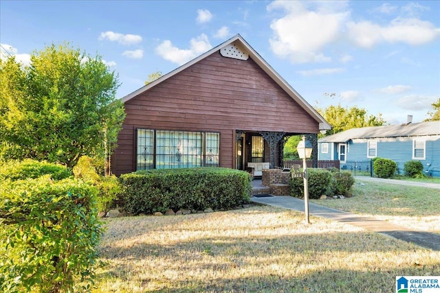 view of front of house with a front yard and covered porch