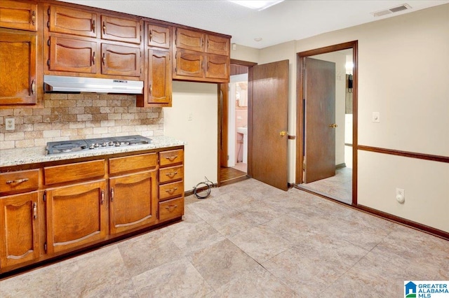 kitchen with stainless steel gas cooktop, backsplash, and light tile patterned floors