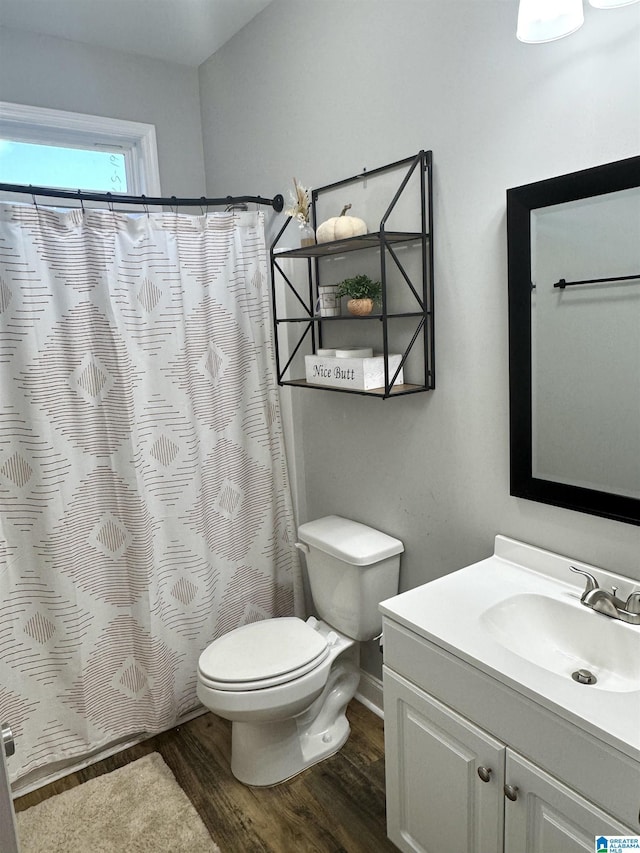 bathroom featuring curtained shower, wood finished floors, toilet, and vanity