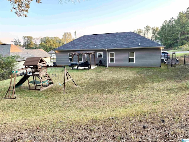 back of house with a playground and a lawn