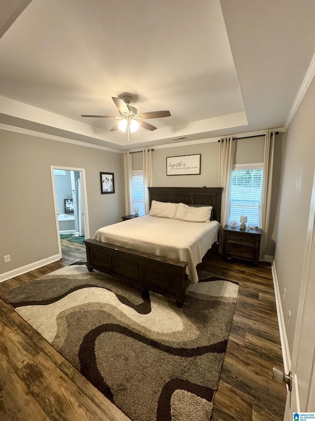 bedroom featuring baseboards, dark wood-style floors, and a raised ceiling