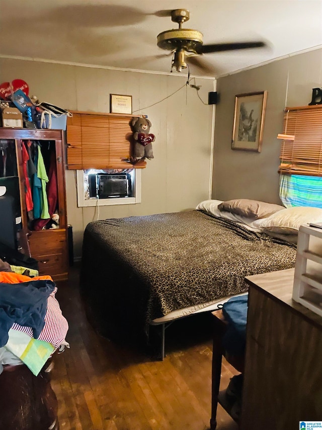 bedroom with cooling unit, ceiling fan, and dark wood-type flooring