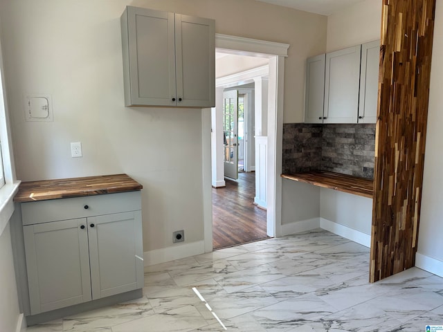 kitchen featuring decorative backsplash, gray cabinets, butcher block counters, and light hardwood / wood-style floors