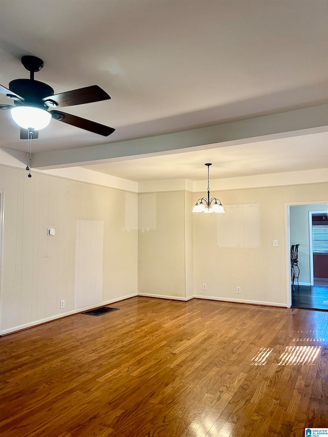 empty room featuring wood-type flooring and ceiling fan with notable chandelier