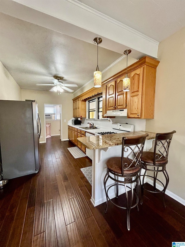 kitchen with sink, kitchen peninsula, stainless steel fridge, pendant lighting, and dark wood-type flooring