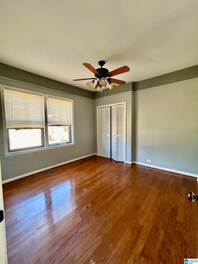 unfurnished bedroom with a closet, ceiling fan, and hardwood / wood-style flooring