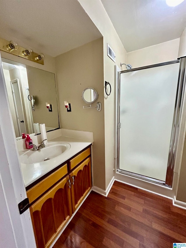 bathroom featuring vanity, hardwood / wood-style flooring, and walk in shower