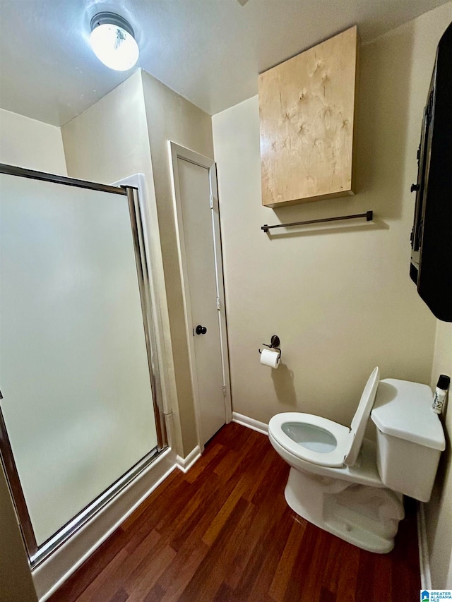 bathroom with toilet, hardwood / wood-style flooring, and walk in shower