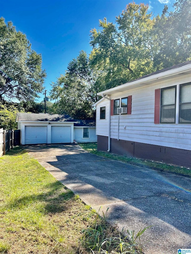 view of front of house featuring a garage, a front lawn, and an outbuilding