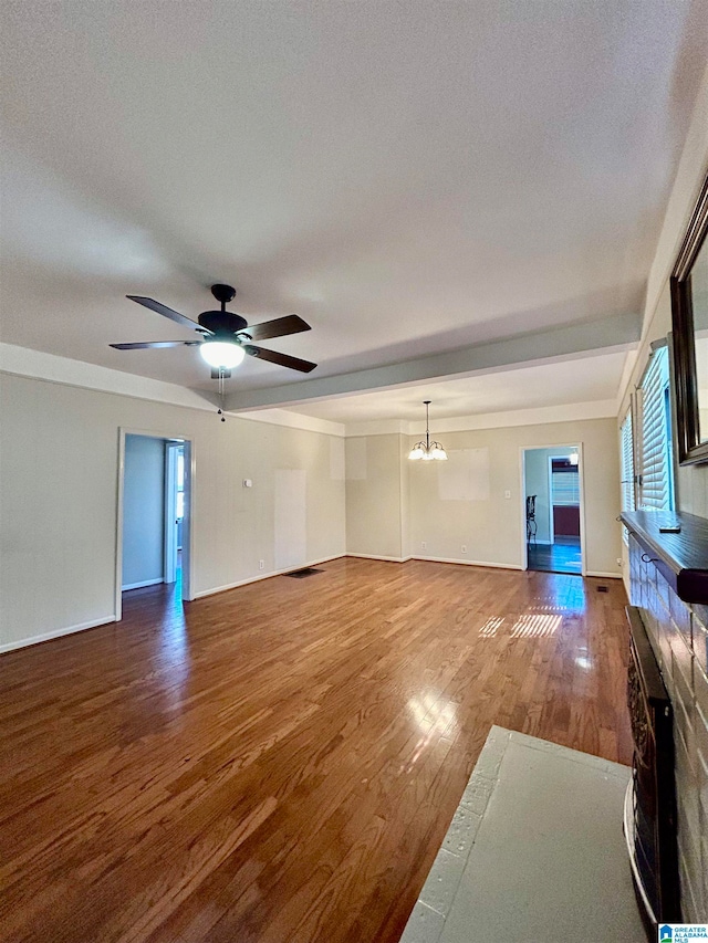 unfurnished living room with wood-type flooring, a textured ceiling, and ceiling fan with notable chandelier