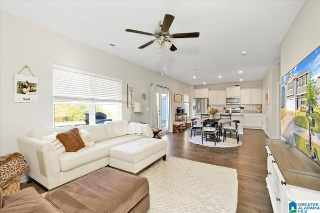 living room featuring ceiling fan and dark hardwood / wood-style floors