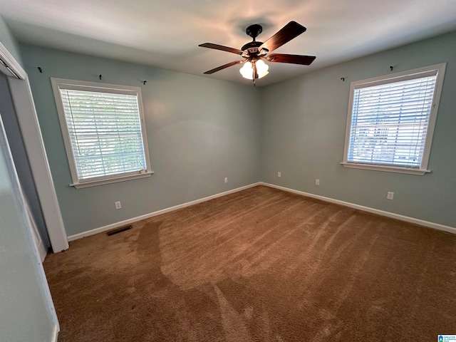 carpeted spare room featuring ceiling fan