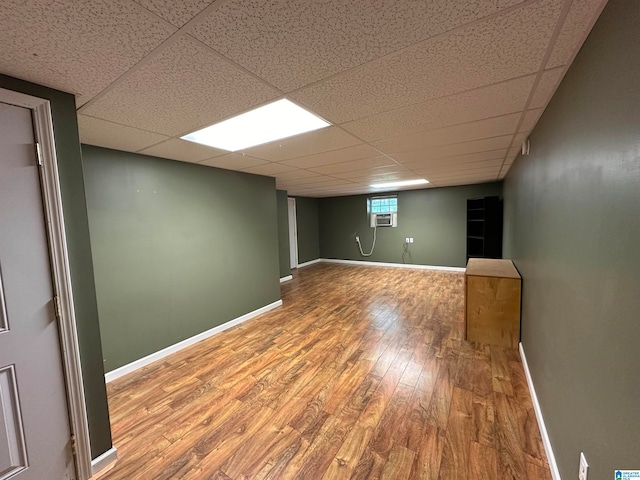 basement with a drop ceiling and hardwood / wood-style floors