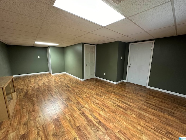 basement featuring a drop ceiling and hardwood / wood-style flooring