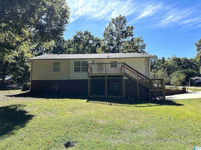 back of property with central AC, a wooden deck, and a lawn