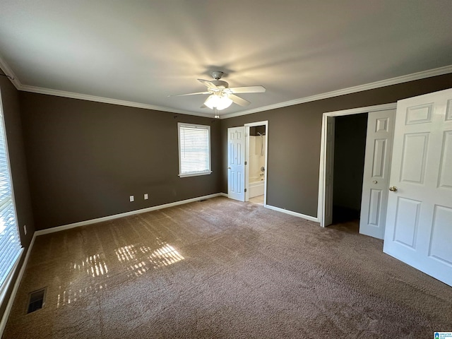 unfurnished bedroom with carpet, ceiling fan, ornamental molding, a closet, and ensuite bath