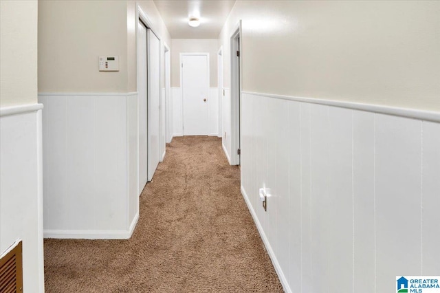 hall with light colored carpet