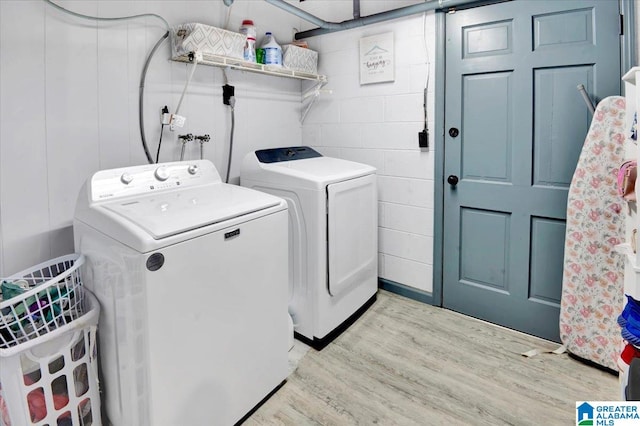 laundry room featuring independent washer and dryer and light hardwood / wood-style floors