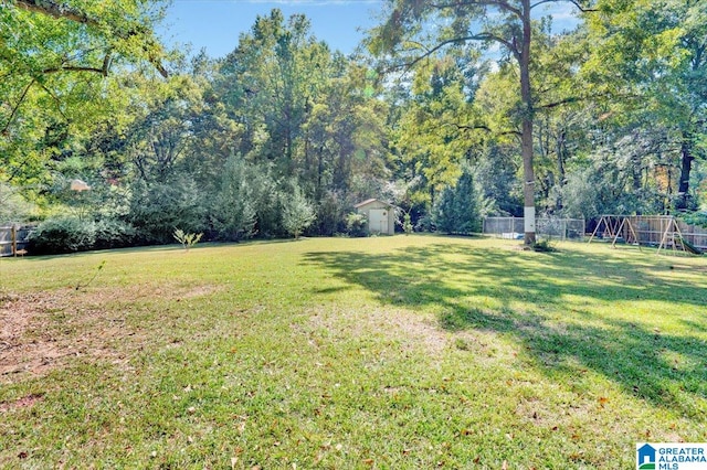 view of yard with a playground and a storage shed