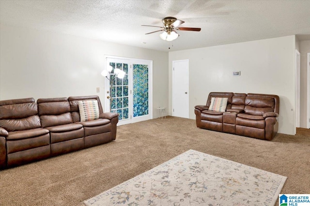 carpeted living room featuring ceiling fan and a textured ceiling