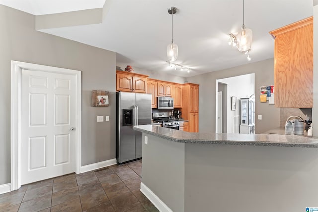 kitchen featuring rail lighting, stainless steel appliances, kitchen peninsula, and pendant lighting